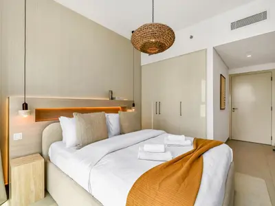 a bedroom with a large white bed and a chandelier at Downtown 4BDR Apartment Opposite Dubai Mall, Burj Khalifa Views in Dubai