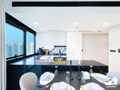 a kitchen with white chairs and a dining room with a view at Luxury 2B with Balcony & Jaccuzi in Business Bay in Dubai