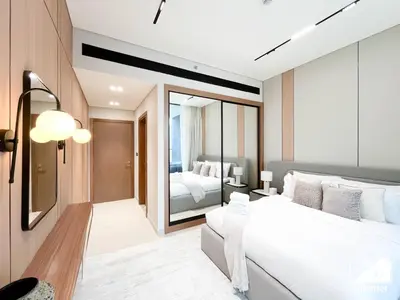 a bedroom with a white bed and a large mirror at Luxury 2B with Balcony & Jaccuzi in Business Bay in Dubai