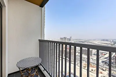 a balcony with a chair and a view of the city at Fancy 1BR apartment The Crest at Sobha Hartland in Dubai