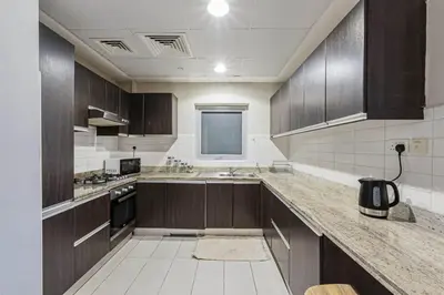 a kitchen with wooden cabinets and a counter top at Dubai Marina Marina Heights 2 beds Sleeps 4 in Dubai