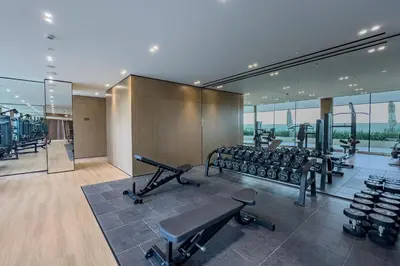 a gym with treadmills and exercise equipment in a building at Studio with Community Views, Steps from Circle Mall and Parks, Near Jebel Ali Racecourse, Binghatti Azure, JVC by Deluxe Holiday Homes in Dubai