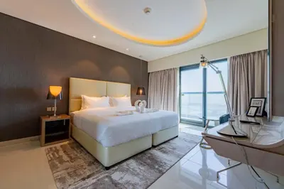 a bedroom with a bed and a desk and a television at TRPS - Paramount Tower D, Business Bay - Premium 1BR Furnished, High Floor, Ready Move In in Dubai