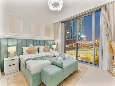 a bedroom with a large bed and a large window at Savis Homes - Canal Front Residence Near Al Wasl Safa Park with Skyline View in Dubai