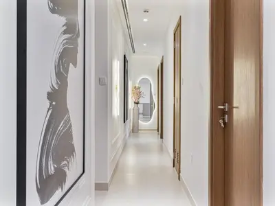 a hallway with white walls and black and white paintings at Savis Homes - Canal Front Residence Near Al Wasl Safa Park with Skyline View in Dubai