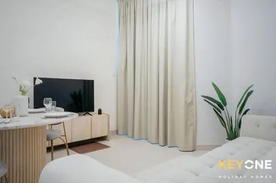 a living room with a television and a white couch at Magnificent Two Bedroom Beachfront in Dubai