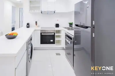 a kitchen with white counters and a refrigerator at Magnificent Two Bedroom Beachfront in Dubai