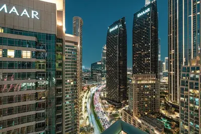 a view of a city at night with tall buildings at Luxe 2 Bed with Burj View, 5 Min Walk to Dubai Mall, PS5 by Vista Stays Dubai Downtown in Dubai