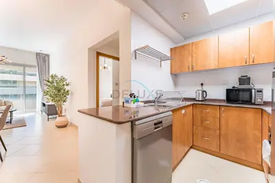 a kitchen with a sink and a dishwasher at Easy Metro and Tram Access 1BR, Offering Partial Canal, SZR, and City Views, Just Minutes from Marina Mall, Marina Diamond 6, Dubai Marina by Deluxe Holiday Homes in Dubai