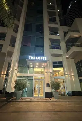a building with a sign that reads the lodges at Downtown Dubai Beautiful Upgraded 1-bedroom apartment in Dubai
