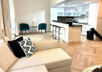 a living room with a couch and a kitchen at Downtown Dubai Beautiful Upgraded 1-bedroom apartment in Dubai