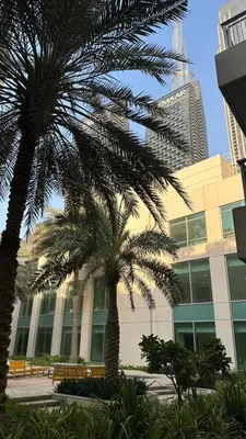 two palm trees in front of a building at Downtown Dubai Beautiful Upgraded 1-bedroom apartment in Dubai