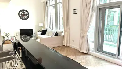 a white living room with a couch and a large window at Downtown Dubai Beautiful Upgraded 1-bedroom apartment in Dubai