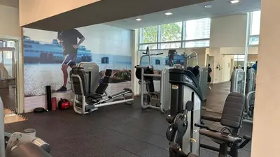 a man standing in a gym with a picture on the wall at Downtown Dubai Beautiful Upgraded 1-bedroom apartment in Dubai