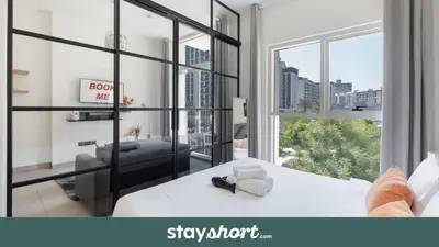 a bedroom with a white bed and a large window at StayShort - Dubai Hills sleeps 4 in a Great Location in Dubai