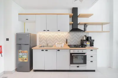 a kitchen with white cabinets and a refrigerator at StayShort - Dubai Hills sleeps 4 in a Great Location in Dubai