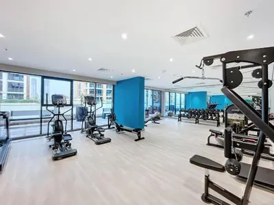 a gym with treadmills and machines in a building at Cozy Studio 15 Min From Burj Khalifa in Dubai