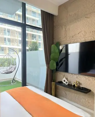 a bedroom with a bed and a large window at Cozy Studio 15 Min From Burj Khalifa in Dubai