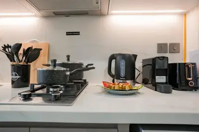 a kitchen counter with a coffee maker and a bowl of fruit at Bright Studio in Azizi Riviera with Patio & Pool in Dubai