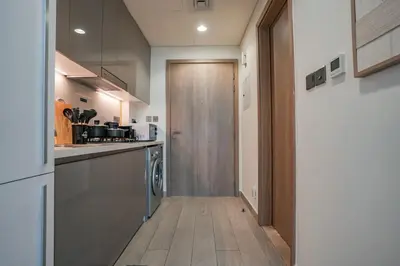 a kitchen with a wooden floor and a door at Bright Studio in Azizi Riviera with Patio & Pool in Dubai