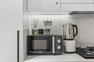 a microwave sitting on top of a kitchen counter at luxury Madrid Studio-Binghatti Azure in Dubai