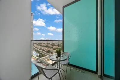 a balcony with a table and chairs and a large window at luxury Madrid Studio-Binghatti Azure in Dubai