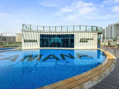 a large swimming pool in front of a building at 2 bedroom apartment with private pool in Dubai