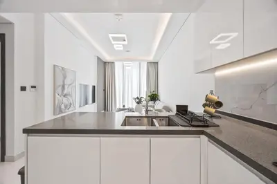 a kitchen with white cabinets and a sink at 2 bedroom apartment with private pool in Dubai