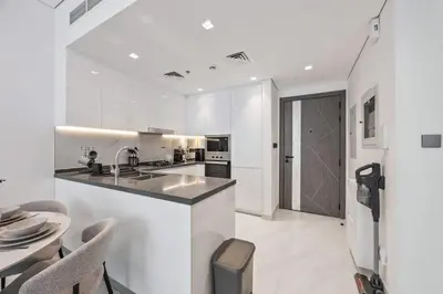 a white kitchen with a sink and a counter at 2 bedroom apartment with private pool in Dubai