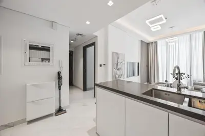 a white kitchen with a sink and a counter at 2 bedroom apartment with private pool in Dubai