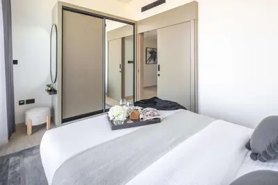 a bedroom with a white bed with a large mirror at Frank Porter - Binghatti Corner in Dubai