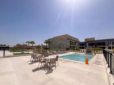 a patio with a table and chairs next to a pool at Frank Porter - Binghatti Corner in Dubai