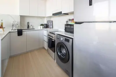 a kitchen with a washing machine and a refrigerator at Frank Porter - Binghatti Corner in Dubai