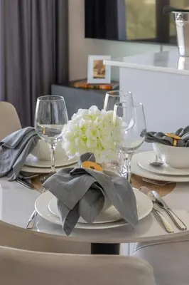 a table with glasses and a plate with flowers on it at Frank Porter - Binghatti Corner in Dubai