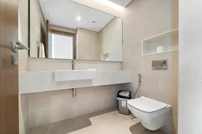 a bathroom with a toilet and a sink and a mirror at Partial Canal View 2BR plus Maid close to Safa Park in Dubai