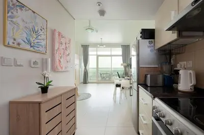 a kitchen with a counter and a table in it at Fully Furnished Studio Hilliana Tower Sea View and Burj View in Dubai