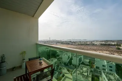 a balcony with a table and a view of a city at Fully Furnished Studio Hilliana Tower Sea View and Burj View in Dubai