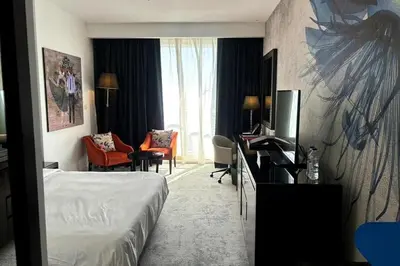 a hotel room with a bed and a desk with a television at Movenpick Apartment JLT in Dubai