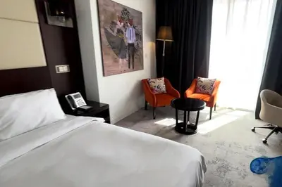 a hotel room with a bed and two chairs at Movenpick Apartment JLT in Dubai