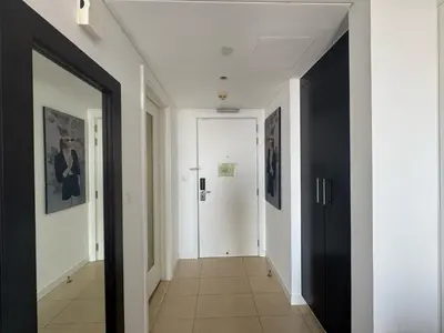 a hallway with black doors and white walls at Movenpick Apartment JLT in Dubai