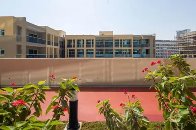 a building in the background with flowers in the foreground at Frank Porter - Jwelz Residence in Dubai