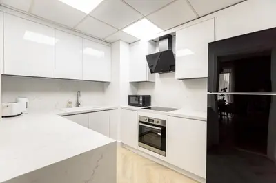 a white kitchen with white cabinets and a counter top at Spacious and luxurious 1 bed with amazing marina view!Rimal ! in Dubai