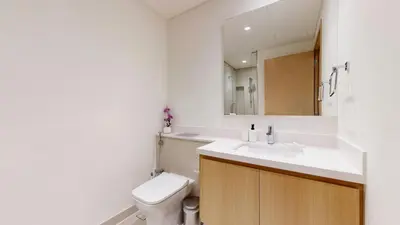 a bathroom with a toilet and a sink and a mirror at Vacationer l Chic 2 Bedroom l Prime Location in Creek Harbour l Pool View in Dubai