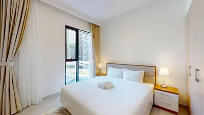 a bedroom with a white bed and a large window at Vacationer l Chic 2 Bedroom l Prime Location in Creek Harbour l Pool View in Dubai