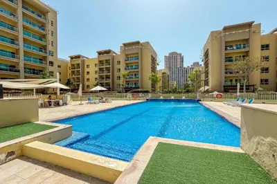 a large swimming pool with buildings in the background at Vacationer l Modern 1 Bedroom l Aesthetic Interior l Free Wi-Fi in Dubai