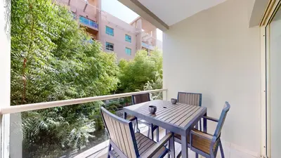 a wooden table and chairs on a balcony at Vacationer l Modern 1 Bedroom l Aesthetic Interior l Free Wi-Fi in Dubai