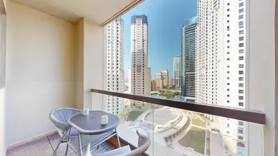 a balcony with a table and chairs and a view of a city at Vacationer I Upgraded , Luxury 2 Bedroom Apartment Near JBR Beach, Prime Spot in Dubai