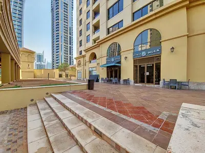an empty street in a city with tall buildings at Vacationer I Upgraded , Luxury 2 Bedroom Apartment Near JBR Beach, Prime Spot in Dubai