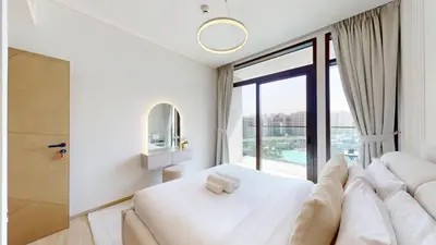 a bedroom with a white bed and a large window at Palace Residences - Two Bedroom with Creek View in Dubai