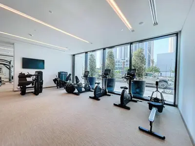 a gym with treadmills and exercise equipment in a building at Palace Residences - Two Bedroom with Creek View in Dubai